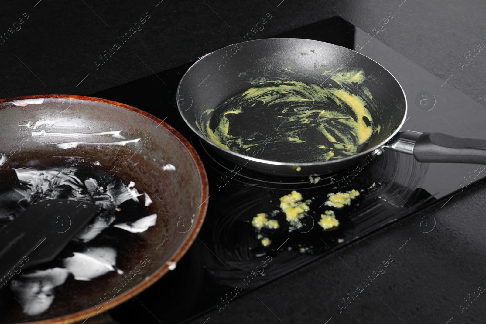 Photo of Dirty frying pans on cooktop in kitchen