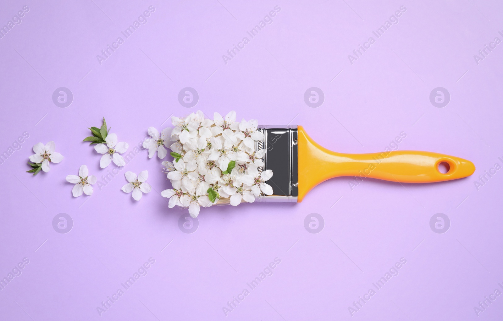 Photo of Paint brush and beautiful flowers on pale violet background, flat lay