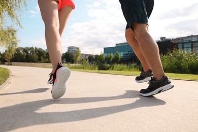 Photo of Healthy lifestyle. Couple running outdoors, closeup view