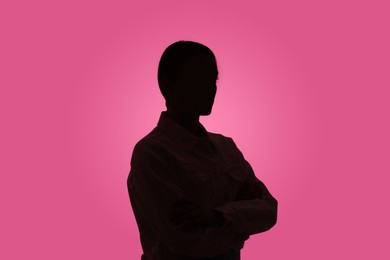 Photo of Silhouette of anonymous woman on pink background
