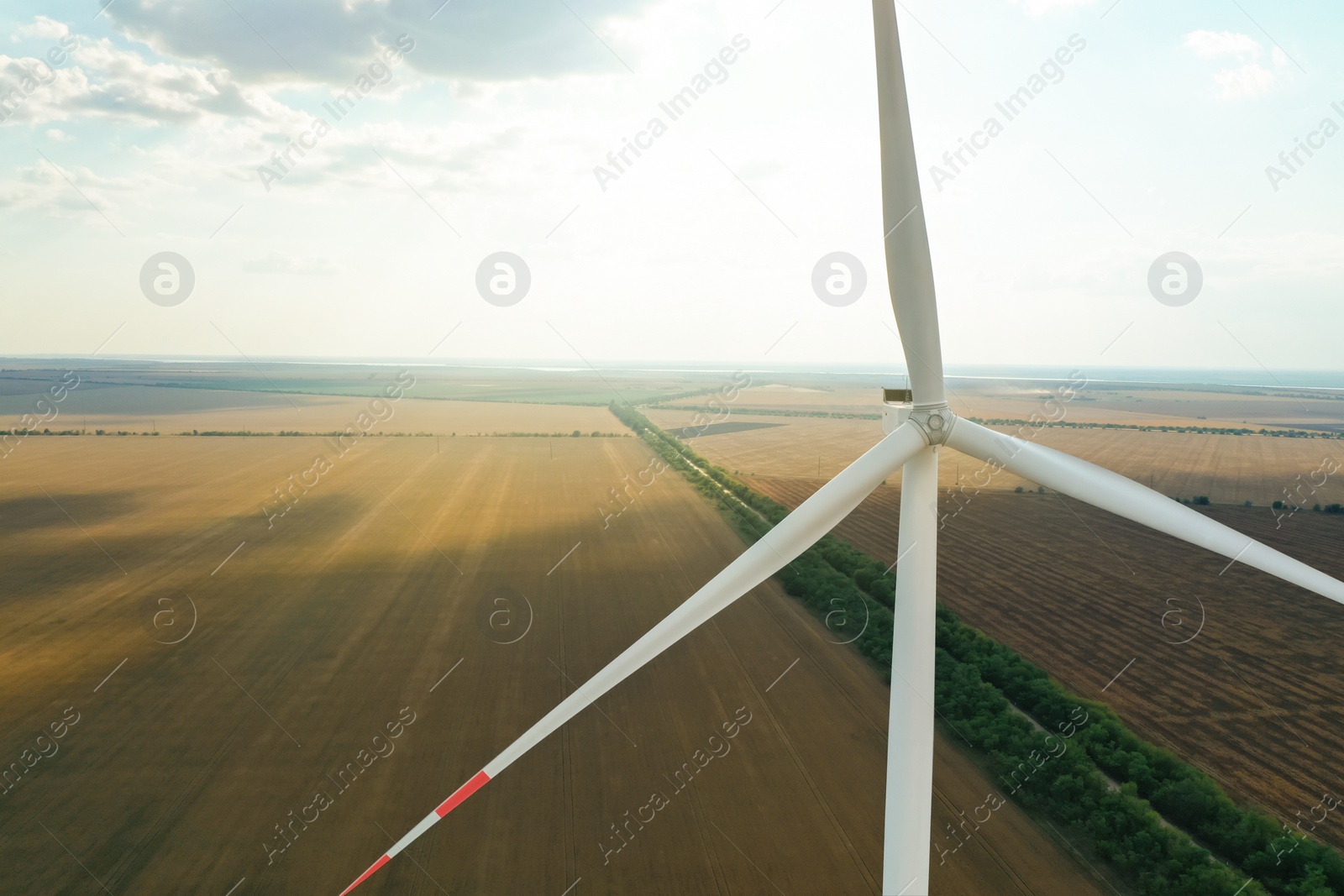 Photo of Modern windmill in field, space for text. Energy efficiency
