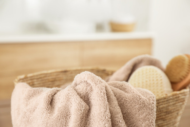 Photo of Wicker basket with clean towel in bathroom, closeup