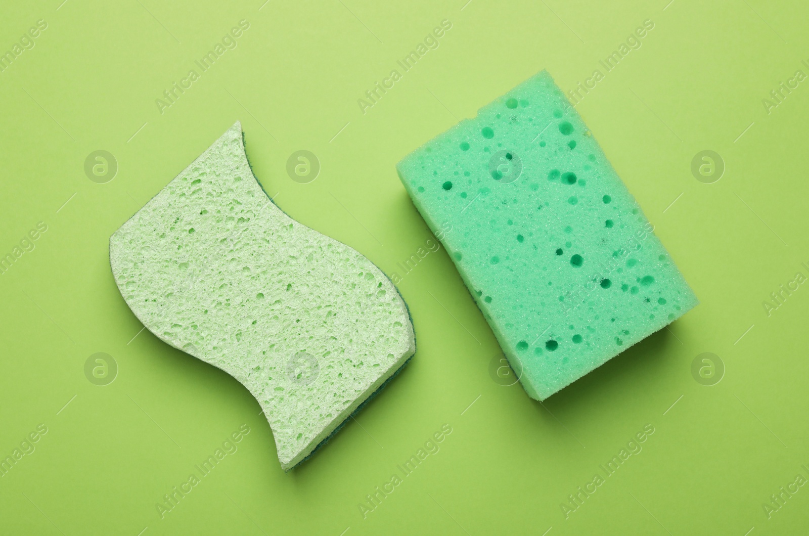 Photo of Color sponges on green background, flat lay