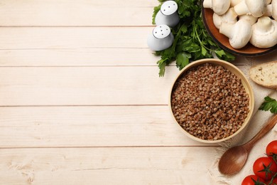 Photo of Tasty buckwheat and products on wooden table, flat lay. Space for text