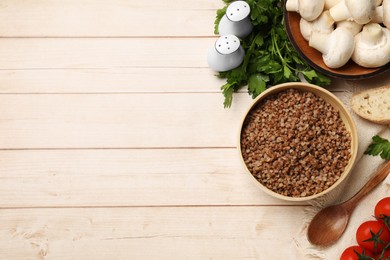 Tasty buckwheat and products on wooden table, flat lay. Space for text