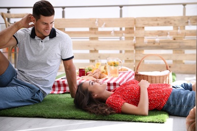 Happy lovely couple imitating picnic at home