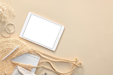 Photo of Flat lay composition with modern tablet on beige background. Space for text