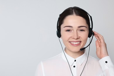 Photo of Hotline operator with modern headset on light grey background, space for text. Customer support