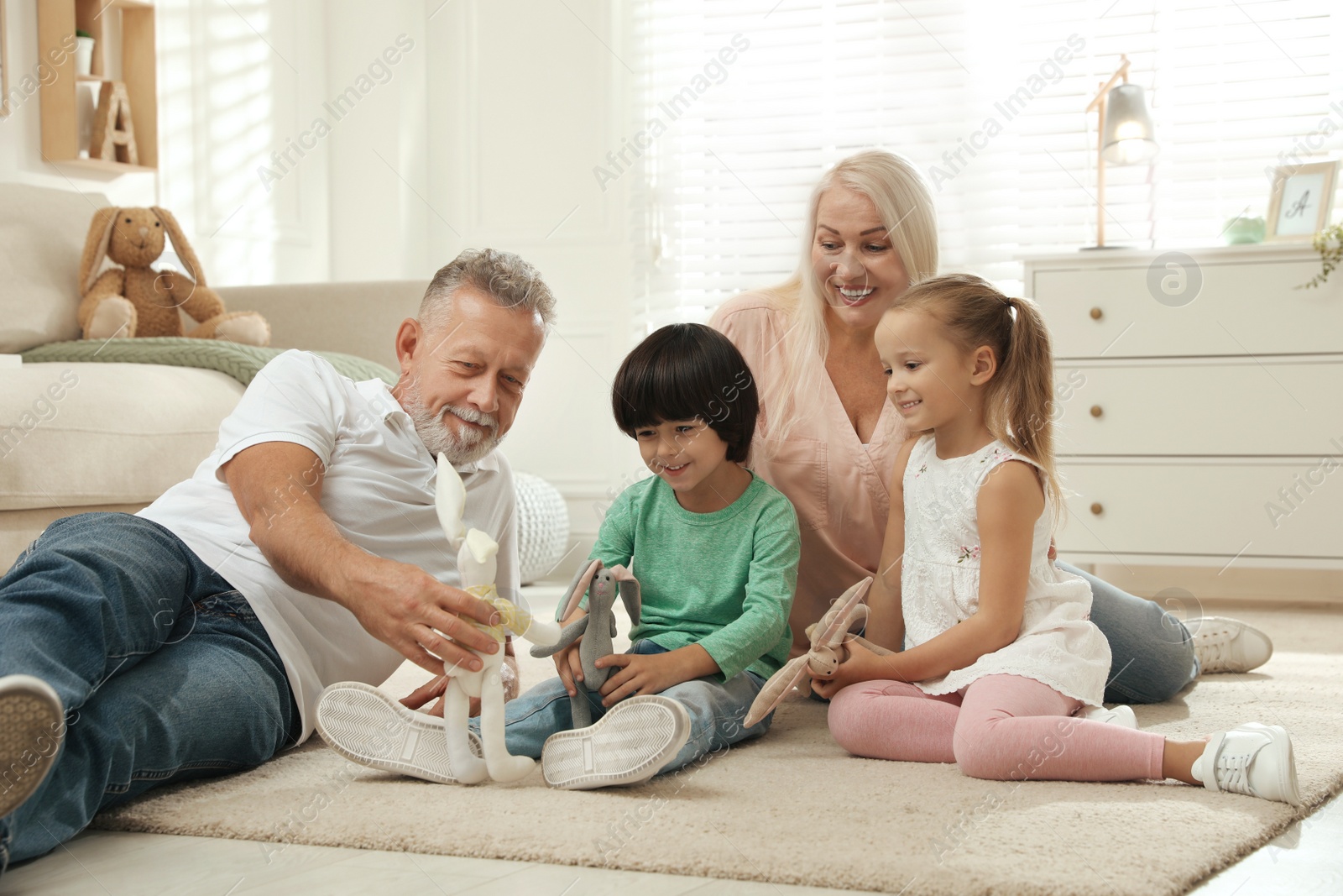 Photo of Happy grandparents and their grandchildren spending time together at home