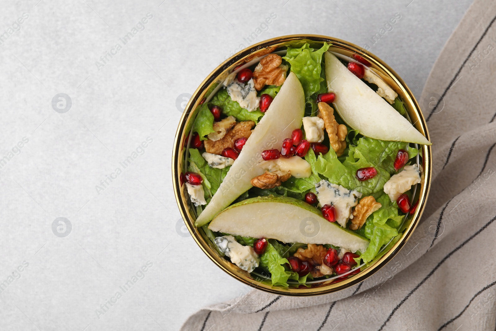 Photo of Delicious pear salad in bowl on light table, top view. Space for text