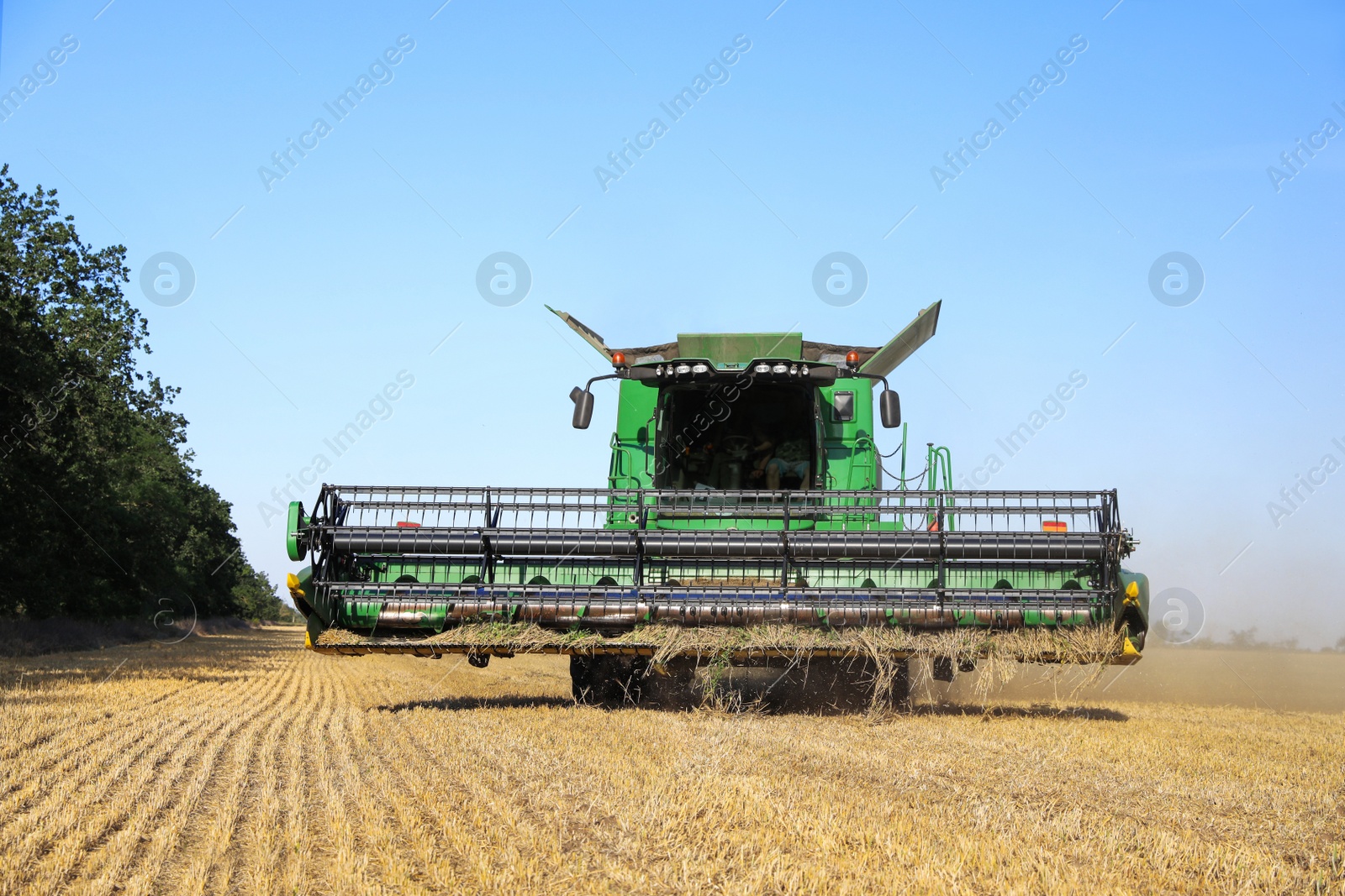 Photo of Modern combine harvester working in agricultural field