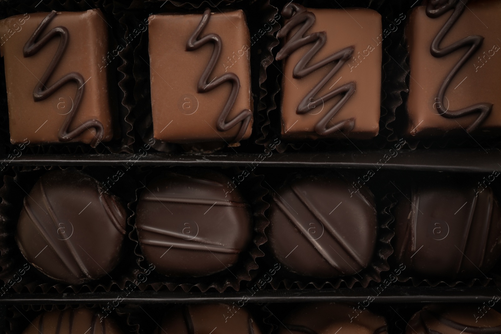 Photo of Many different chocolate candies in box, closeup