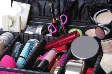 Photo of Stylish case with makeup products and beauty accessories, closeup