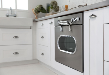 Photo of New modern oven in stylish kitchen. Cooking appliance