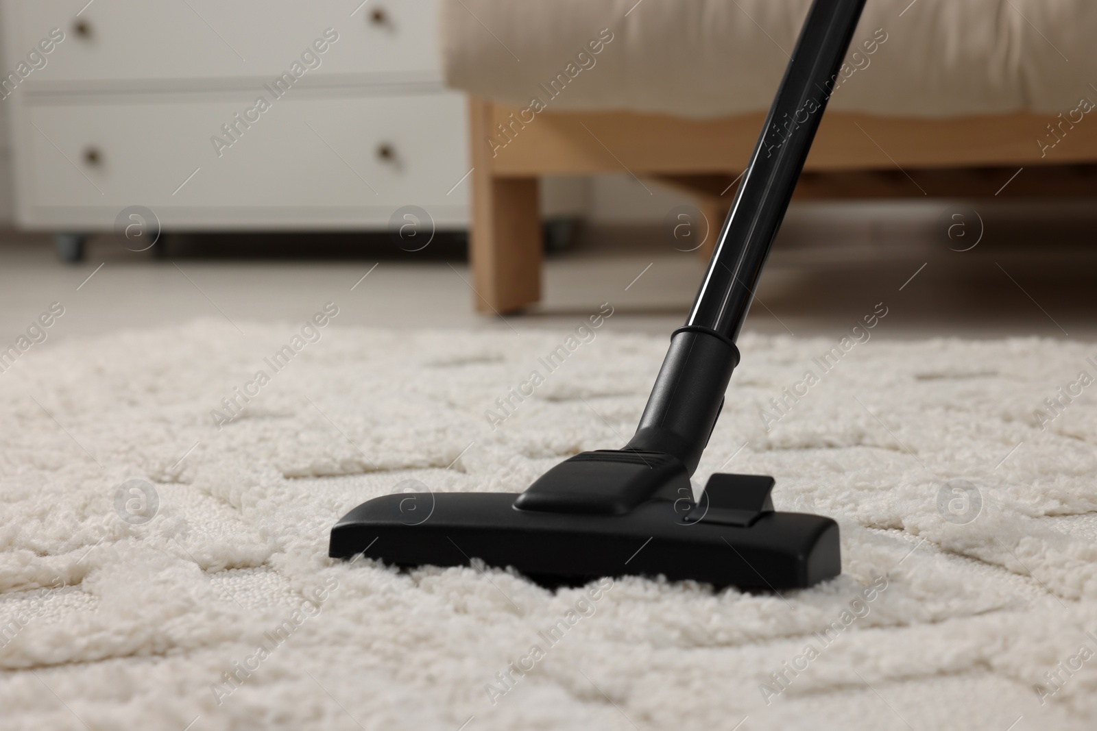 Photo of Hoovering carpet with vacuum cleaner indoors, closeup