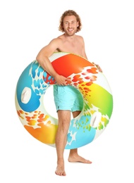 Photo of Attractive young man in swimwear with colorful inflatable ring on white background