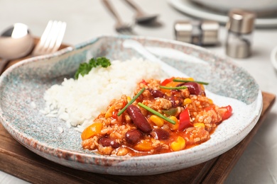 Photo of Plate of tasty chili con carne with rice on gray table