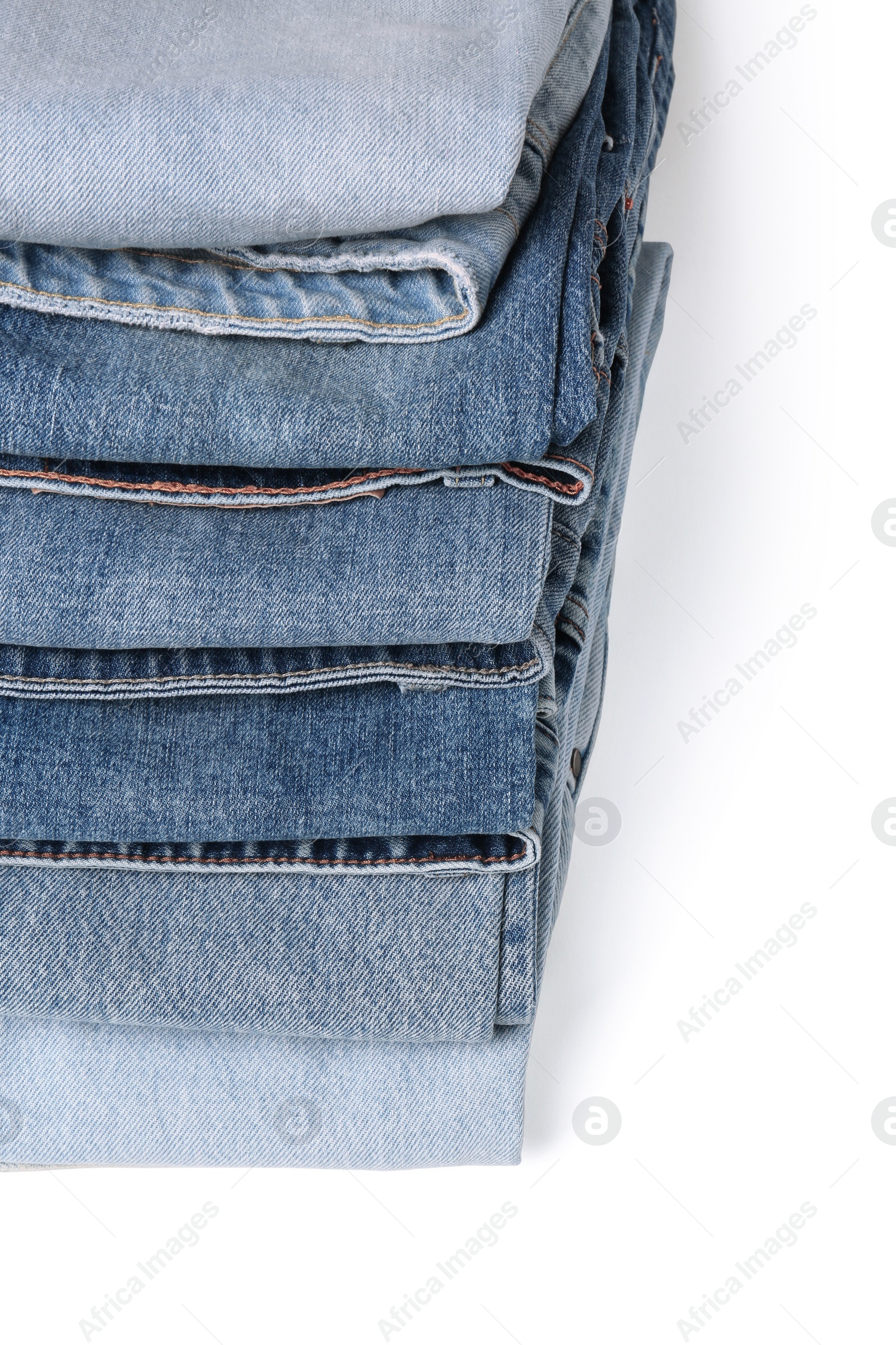 Image of Stack of different folded jeans isolated on white