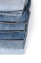 Stack of different folded jeans isolated on white