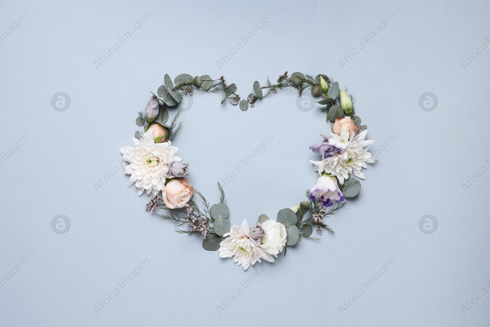 Photo of Beautiful heart made of different flowers on light gray background, flat lay. Space for text