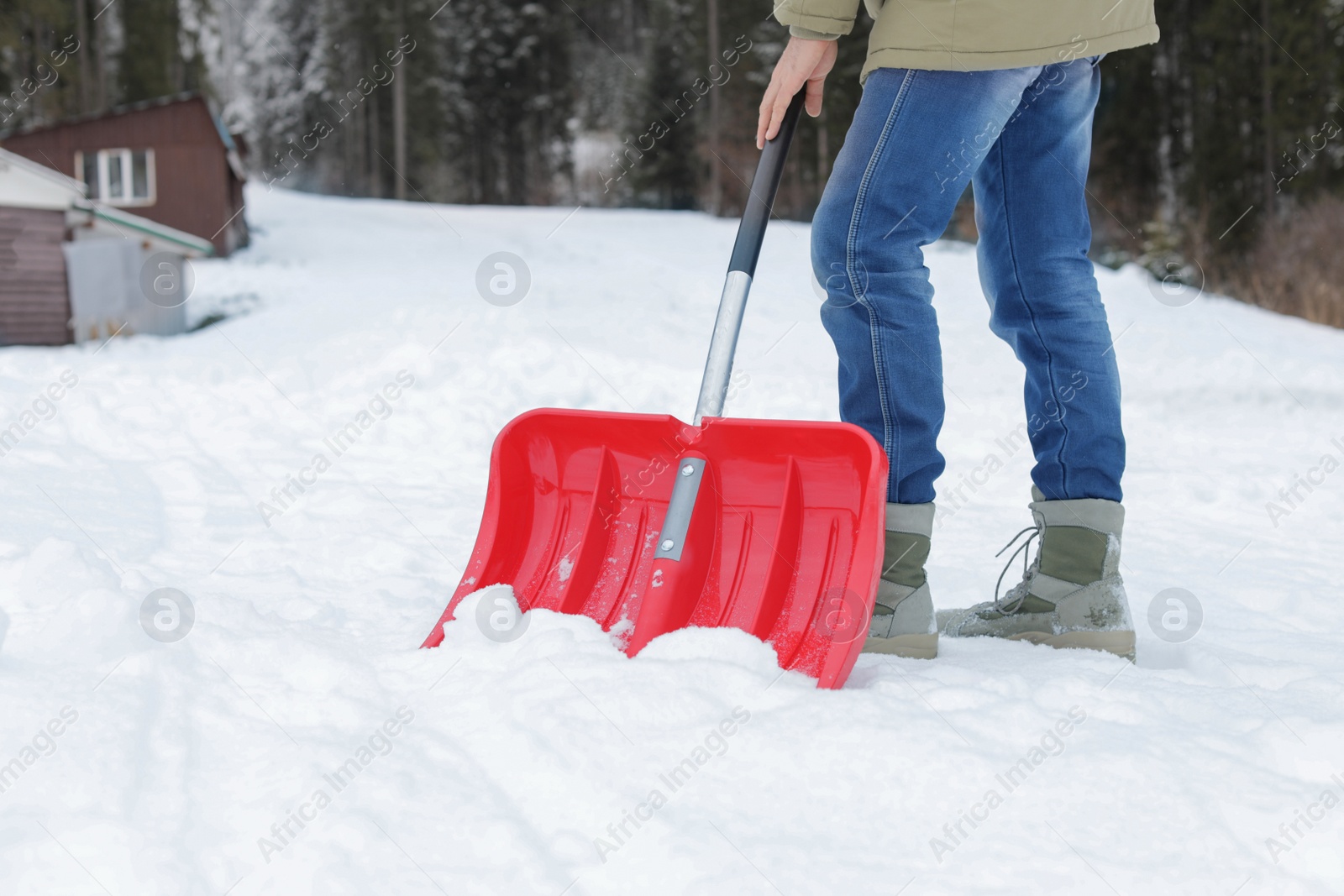 Photo of Man removing snow with shovel near house