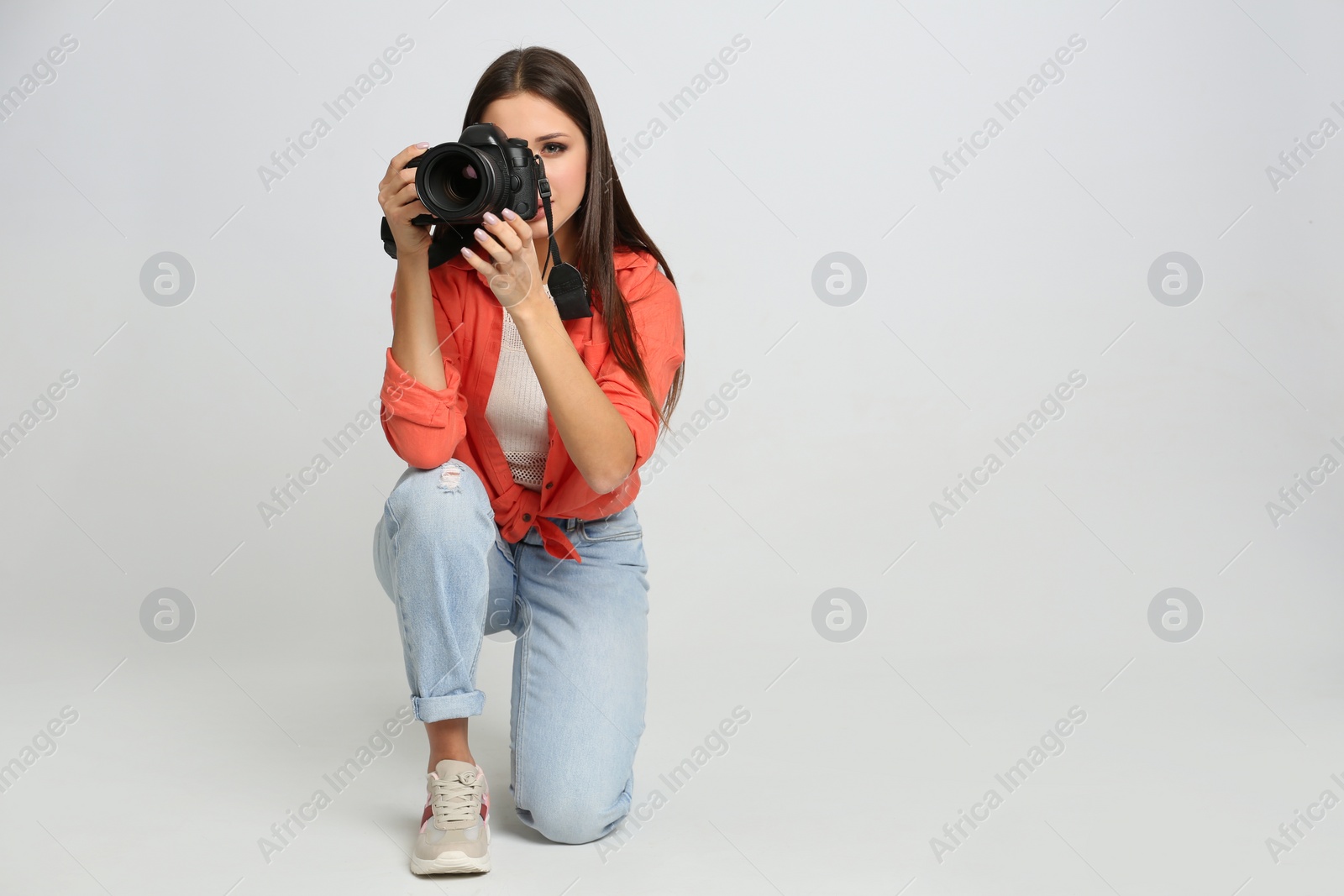 Photo of Professional photographer working on white background in studio