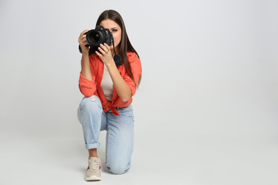 Photo of Professional photographer working on white background in studio