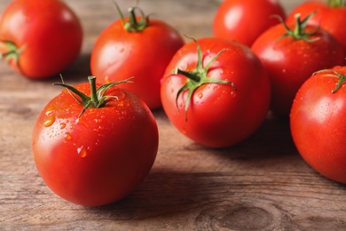 Fresh ripe tomatoes on wooden table, closeup