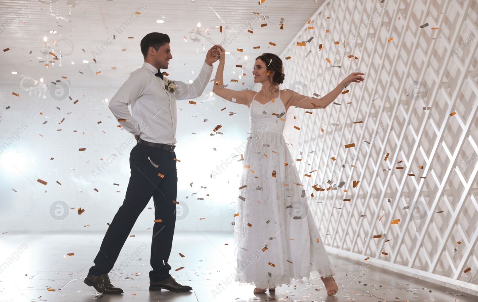 Photo of Happy newlywed couple dancing together in festive hall