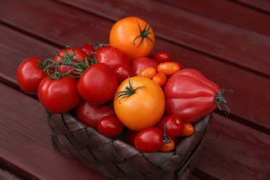 Basket with fresh tomatoes on wooden table