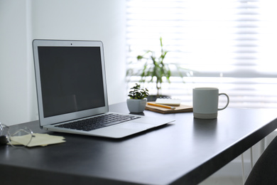 Photo of Modern laptop on office table. Stylish workplace