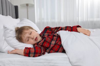 Little boy snoring while sleeping in bed at home