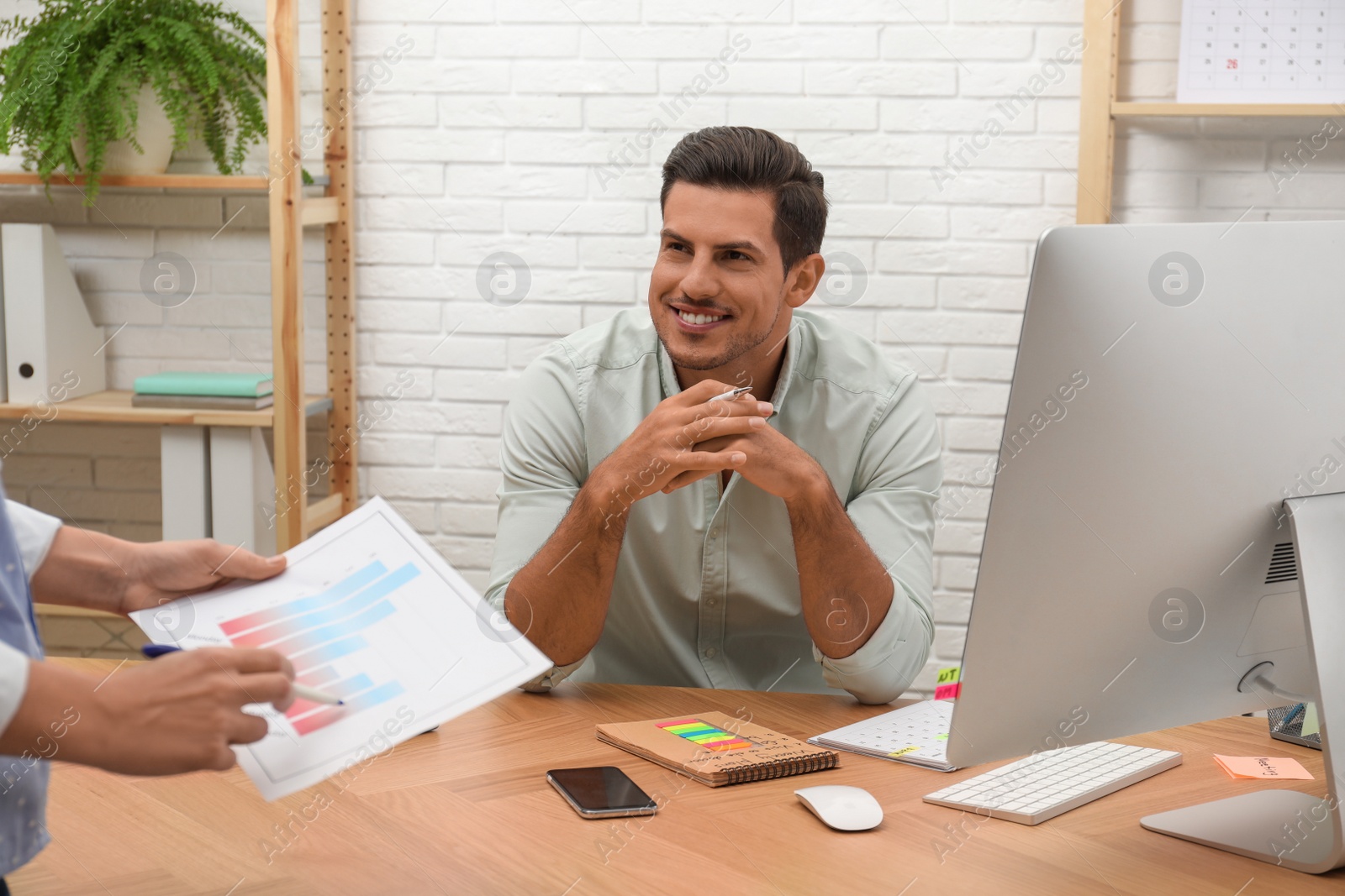 Photo of Colleagues making schedule using calendar in office