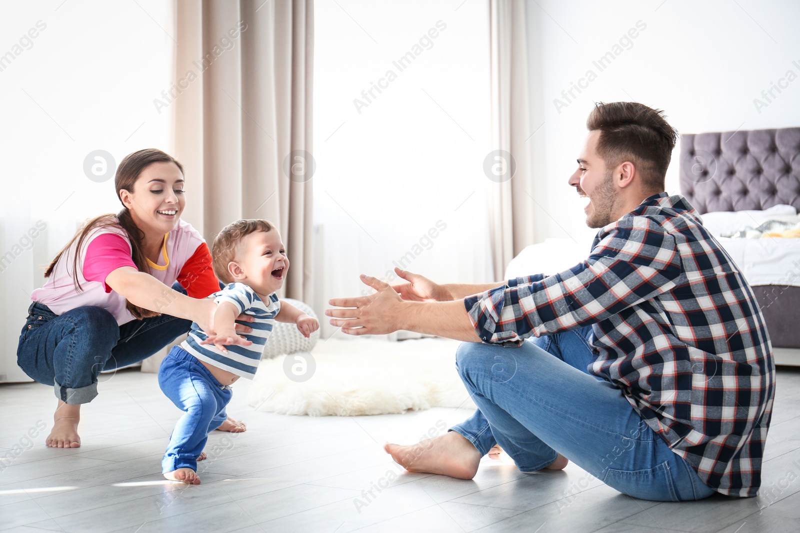 Photo of Happy family playing and baby learning to walk at home