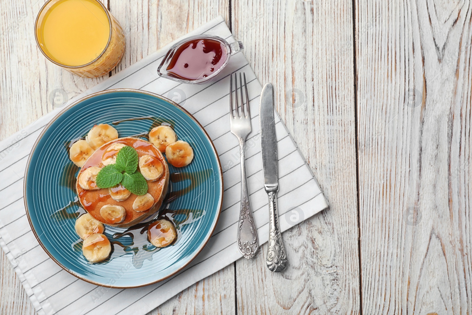 Photo of Plate with delicious pancakes on wooden table