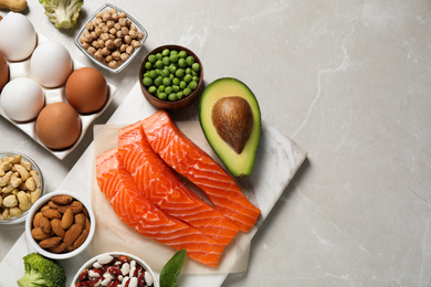 Photo of Products rich in protein on light marble table, flat lay