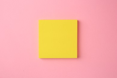 Blank paper note on pink background, top view