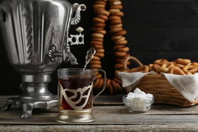 Photo of Delicious tea and ring shaped Sushki (dry bagels), focus on cup with samovar. Space for text