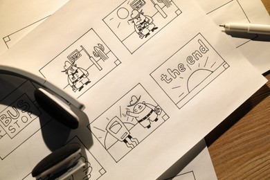 Photo of Storyboards with cartoon sketches at workplace, flat lay. Pre-production process