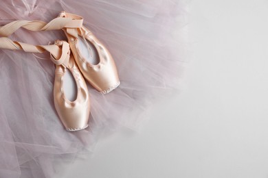 Ballet shoes. Elegant pointes and tutu on light grey background, top view. Space for text
