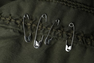 Top view of metal safety pins on clothing