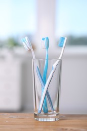 Photo of Plastic toothbrushes in holder on wooden table