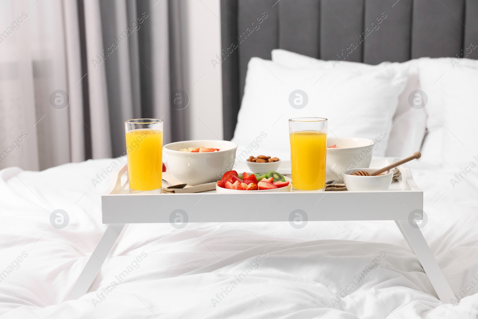 Tray with tasty breakfast on bed at home Photo of Tray with tasty breakfast on bed at home