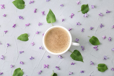 Photo of Flat lay composition with beautiful blossoming lilac and cup of coffee on light background. Spring flowers