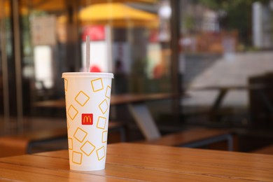 Photo of MYKOLAIV, UKRAINE - AUGUST 11, 2021: Cold McDonald's drink on table in cafe. Space for text