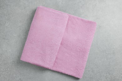 Photo of Soft folded towel on gray background, top view