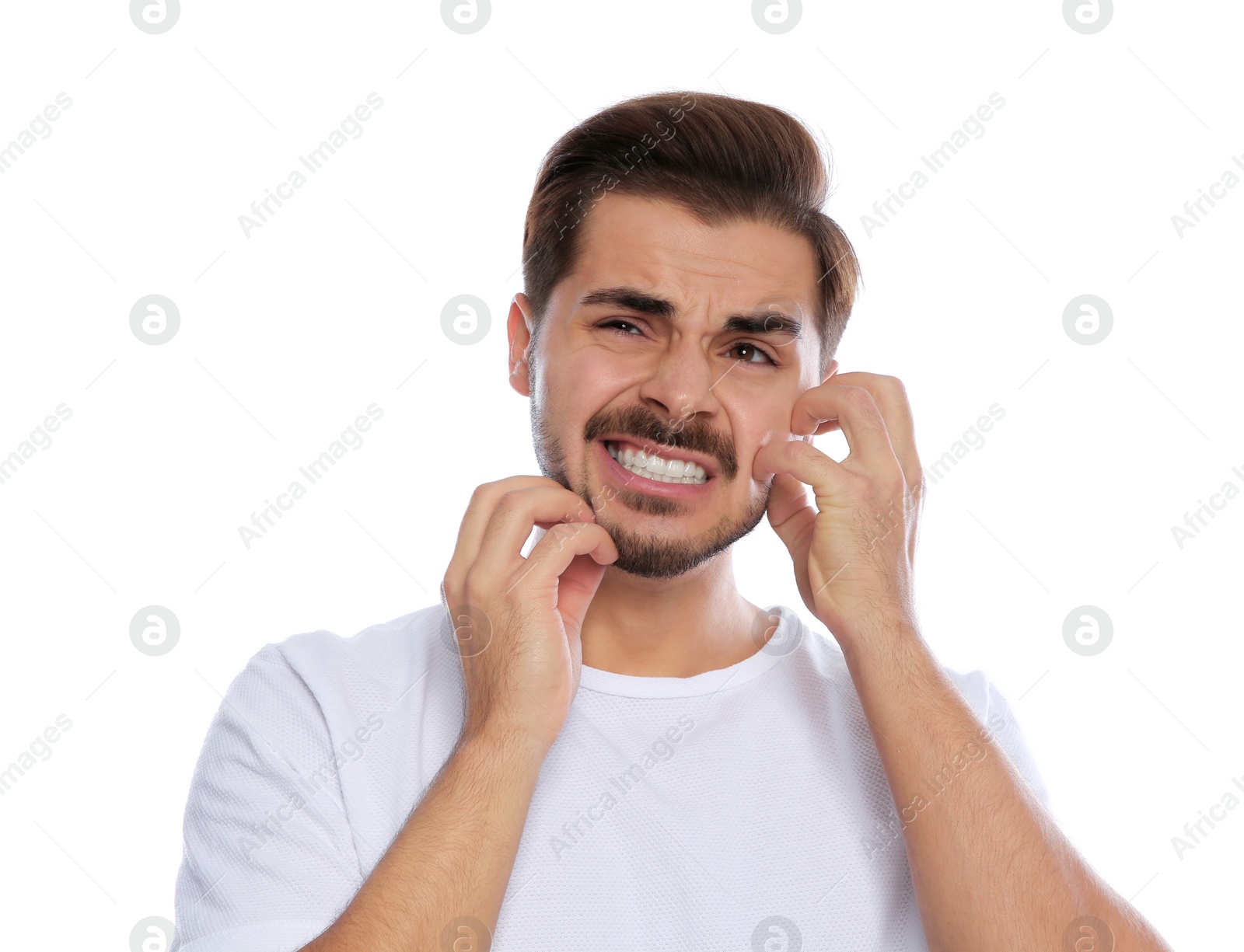 Photo of Young man scratching face on white background. Annoying itch