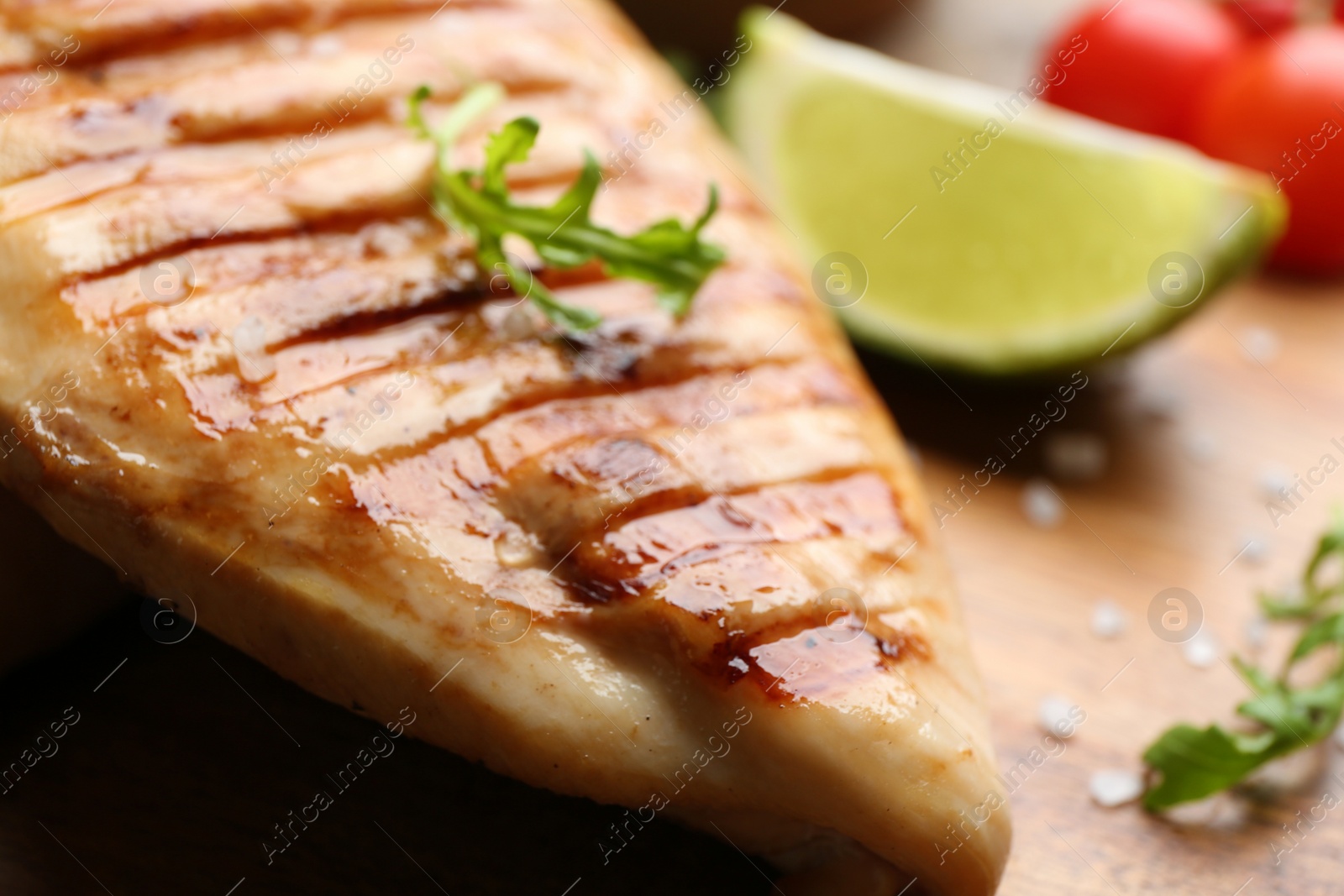 Photo of Tasty grilled chicken fillet with arugula on table, closeup