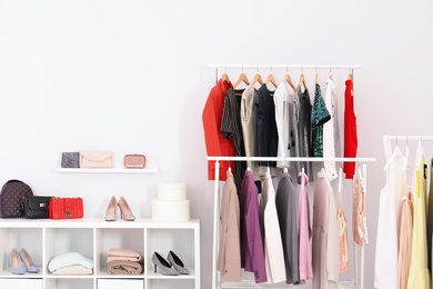 Photo of Racks with clothes in stylish dressing room interior