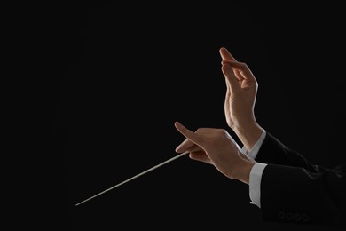 Photo of Professional conductor with baton on black background, closeup. Space for text